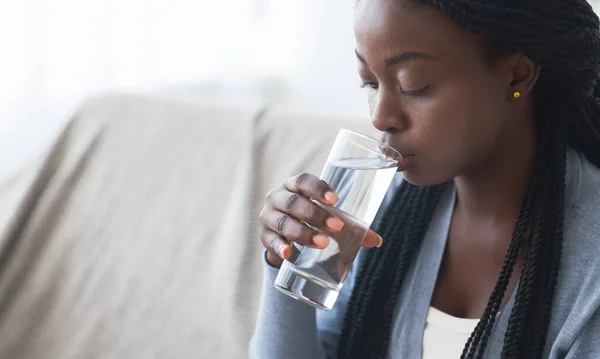 Assetato nero ragazza bere acqua pulita da vetro a casa — Foto Stock