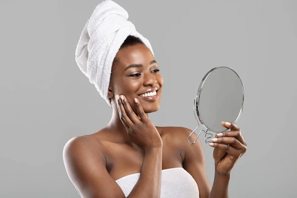 Mulher africana bonita segurando espelho e tocando sua pele macia perfeita — Fotografia de Stock