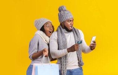 Akıllı telefona bakıp internetten alışveriş yapan afro çift hayret verici.