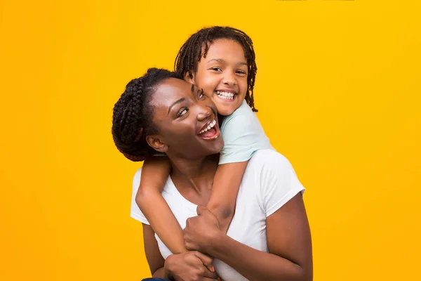 Černá dcera objímající její šťastný veselý matka — Stock fotografie