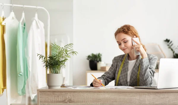 Jovem designer de moda discutir a ordem dos clientes no telefone — Fotografia de Stock