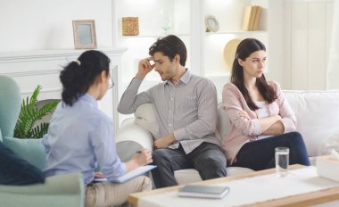 Aile terapisti ofisinde oturan umutsuz genç çift.