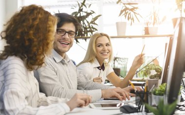 Neşeli iş ekibi yeni pazarlama fikirlerinin tadını çıkarıyor.