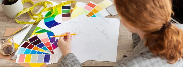 Diseñador de moda dibujando nuevos bocetos, trabajando en el taller —  Fotos de Stock