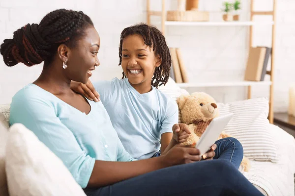 Černá matka ukazuje své dceři nějaké fotky — Stock fotografie