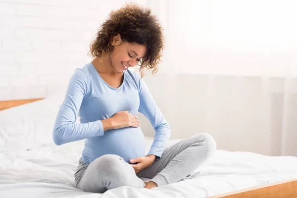 Jolie femme enceinte caressant son ventre, parlant à son bébé — Photo