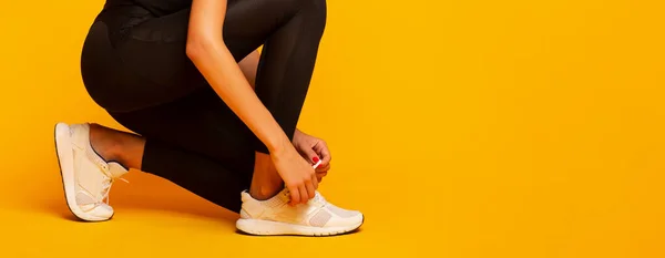 Unrecognizable Lady Lacing Shoes Before Fitness Workout, Yellow Background, Panorama — Stock Photo, Image