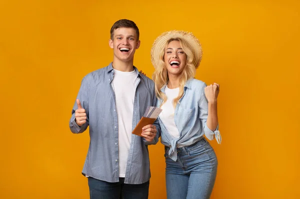 Pareja alegre sosteniendo pasaportes con boletos, celebrando futuras vacaciones —  Fotos de Stock