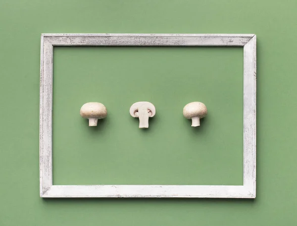 Organic mushrooms surrounded by wooden frame on green — Stock Photo, Image