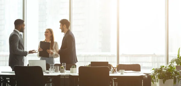 Framgångsrika företagare som talar tillsammans framför kontorsfönster — Stockfoto