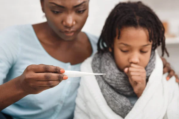 Close-up of afro woman with daughter having cold — ストック写真