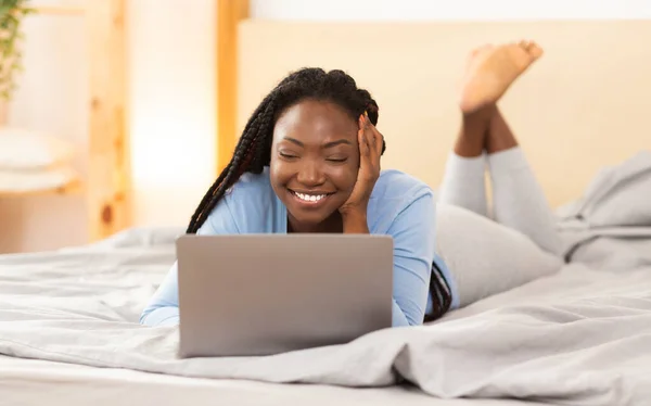 Estudiante chica usando portátil comunicándose con la familia acostada en la cama — Foto de Stock