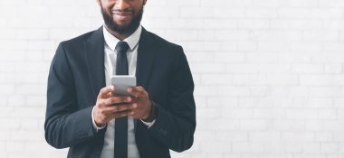 Siyah iş adamının telefon kullanırken çekilmiş fotoğrafı.