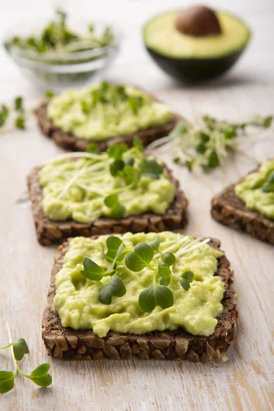 Whole grain sandwiches with avocado spread and microgreen — Stock Photo, Image