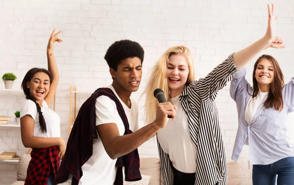 Друзья-подростки веселятся и поют караоке — стоковое фото