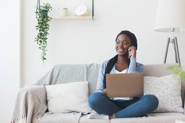 Afro ragazza parlando sul cellulare e utilizzando il computer portatile a casa — Foto Stock