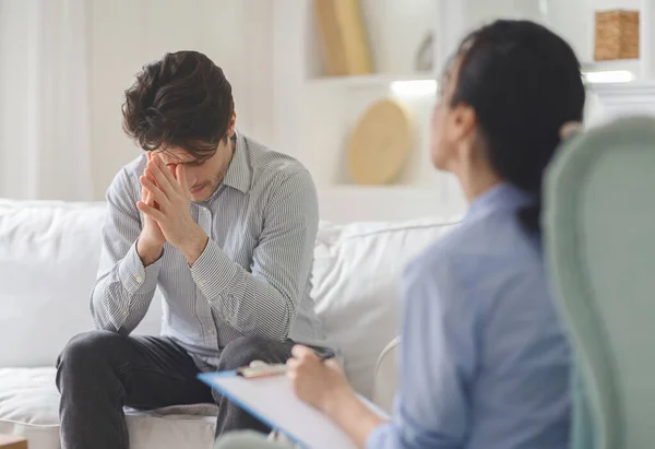 Hombre con problemas sintiéndose mal en la sesión de terapeuta — Foto de Stock