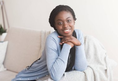 Mutlu Afro Kadın Kanepede Dinleniyor ve Kameraya Bakıyor