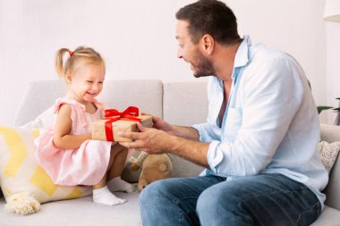 Sevimli küçük kızını tebrik eden neşeli bir baba.