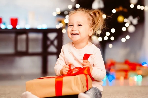 Linda niña abriendo regalo de Navidad en casa —  Fotos de Stock
