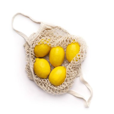 Yeniden kullanılabilir ağ torbasının içindeki taze limonlar beyaza izole edilmiş.