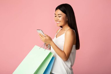 Mevsimlik satışlar. Telefon ve alışveriş torbalarıyla heyecanlı bir kız.