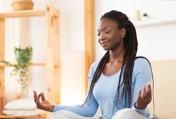 Афроамериканка медитирует в постели дома — стоковое фото