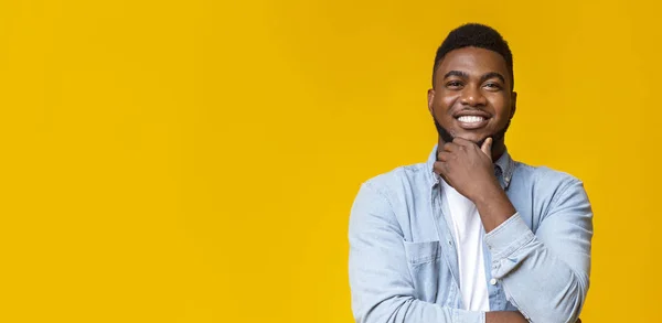 Glimlachende Afrikaanse man aanraken van zijn baard op gele achtergrond — Stockfoto