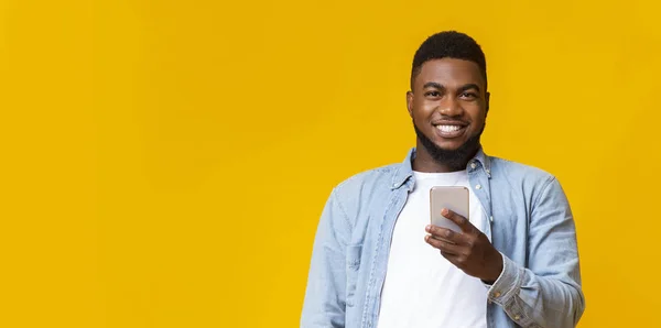 Retrato del negro sonriente con smartphone en las manos — Foto de Stock