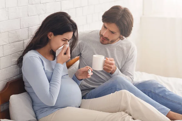 Make som tar hand om sin sjuka gravida fru som lider av influensa — Stockfoto