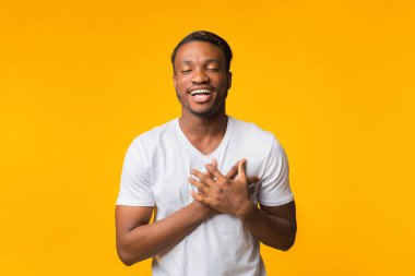 Touched Black Man Pressing Hands To Chest Standing, Yellow Background clipart
