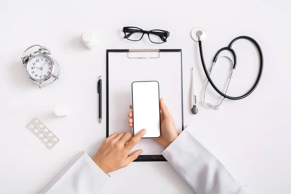 Male doctor hands using smartphone with blank screen, top view — Stock Photo, Image