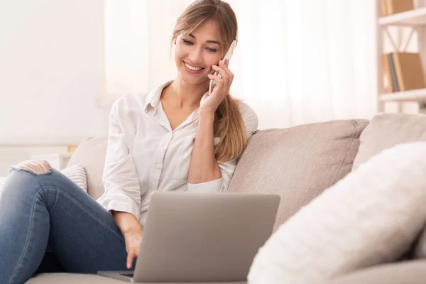 Gelukkig vrouw praten op telefoon zitten op bank thuis — Stockfoto