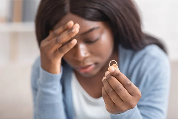 Upset black girl holding gold wedding ring, depressed about divorce — Stock Photo, Image