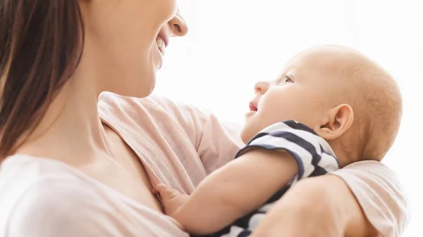 Lindo recién nacido acostado en brazos de madres y mirando a mamá —  Fotos de Stock