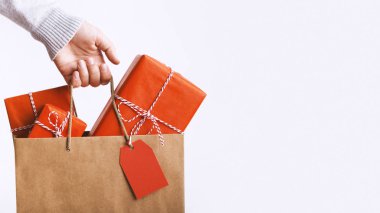 Woman holding Christmas shopping bag on white
