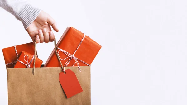 Woman holding Christmas shopping bag on white — ストック写真