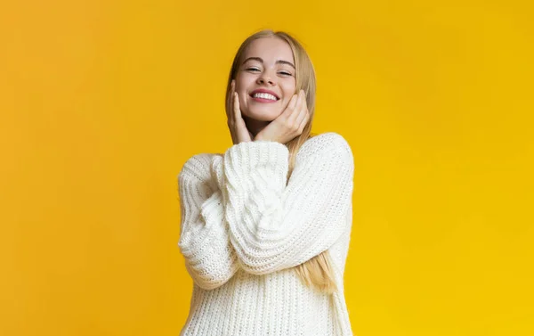 Menina loira alegre tocando seu rosto e sorrindo — Fotografia de Stock