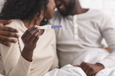 Mutlu Afrikalı Amerikalı çift hamilelik testi pozitif sonuç veriyor.
