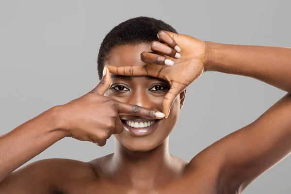 Aantrekkelijke afro vrouw framing haar mooie ogen met vingers — Stockfoto