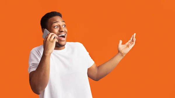 Verrast zwarte man praten aan de telefoon en gebaren — Stockfoto