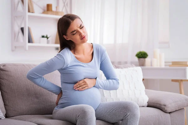 Pregnant Lady Having Backache Massaging Back Sitting On Sofa Indoor — Stock Photo, Image