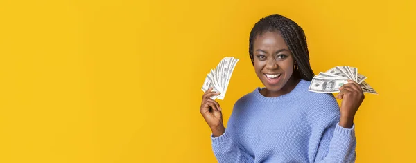 Ragazza afro emotivo con denaro contante dollaro su sfondo giallo — Foto Stock