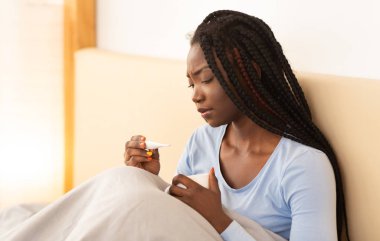 Afro-Amerikalı Kız Ateşli Bir Termometre Tutuyor Yatakta Oturuyor
