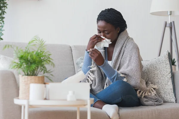 Chica negra que tiene gripe, sonarse la nariz y comprobar la temperatura corporal — Foto de Stock