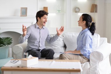 Cheerful young man talking to psychologist emotionally