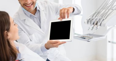 Boş dijital tablet ekranı gösteren kırpılmış dişçi resmi