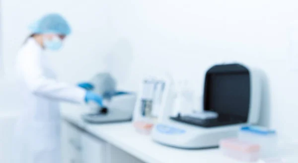 Foto borrosa de una mujer trabajando en un laboratorio moderno — Foto de Stock