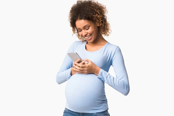 Beyaz arka planda akıllı telefon kullanan Afro-Amerikalı hamile kadın — Stok fotoğraf