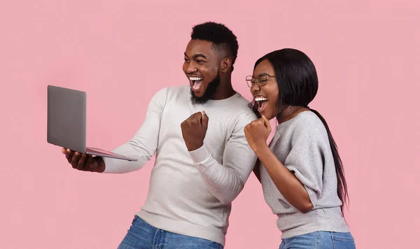 Feliz pareja negra celebrando el éxito con el ordenador portátil —  Fotos de Stock